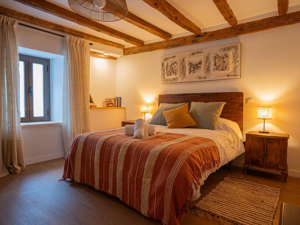 a bedroom with a bed and two lamps and a window at Refugio 1900 in San Cristóbal de Segovia