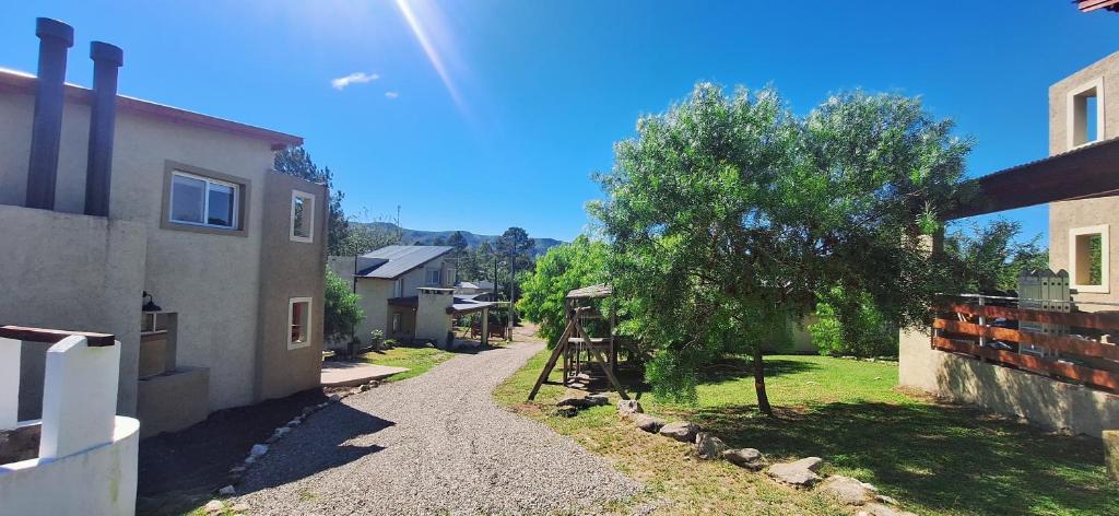 a road next to a house and a tree at Terrazas de Nahuascat in Santa Rosa de Calamuchita