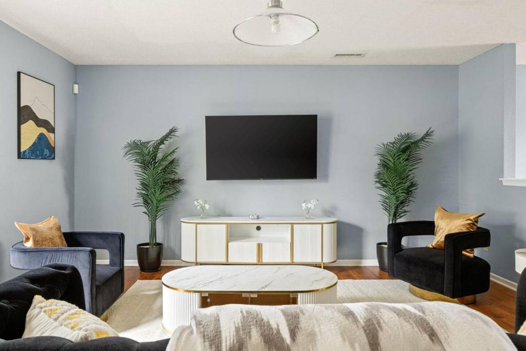 a living room with a couch and a tv on a wall at Quiet Avon Retreat in Indianapolis