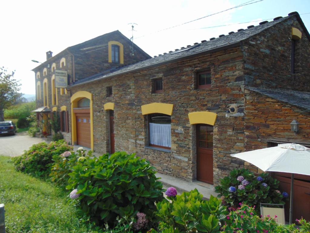 a brick house with an umbrella in front of it at Casa Venancio in Trabada
