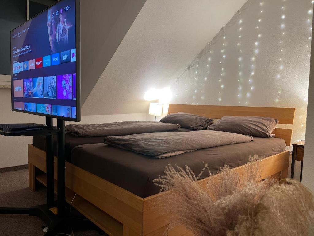 a bedroom with a bed with a large screen at Gut und Günstig in Leipzig - zentrumsnah - inkl Fahrräder, Netflix und Tiefgaragenstellplatz in Leipzig