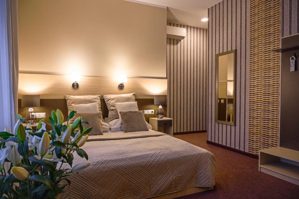 a bedroom with a large bed and a plant at Hotel Kazimierz II in Krakow