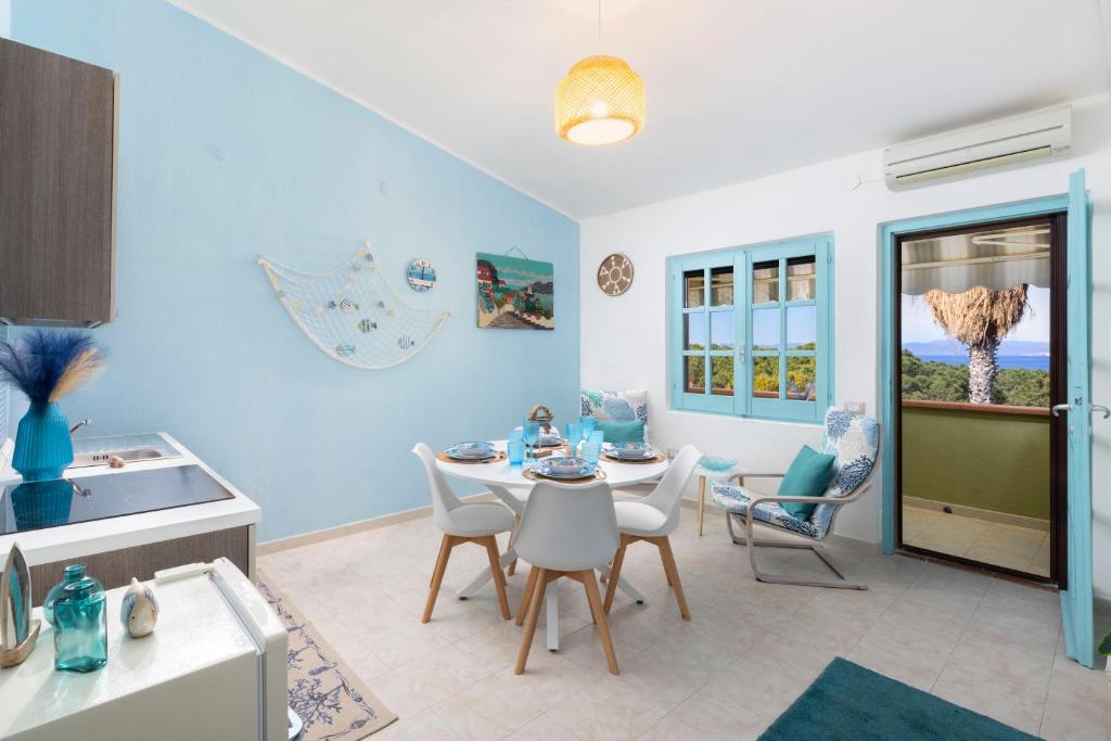 a kitchen with a table and chairs in a room at Blue View - A Due Passi dal Mare & Natura in Quartu SantʼElena