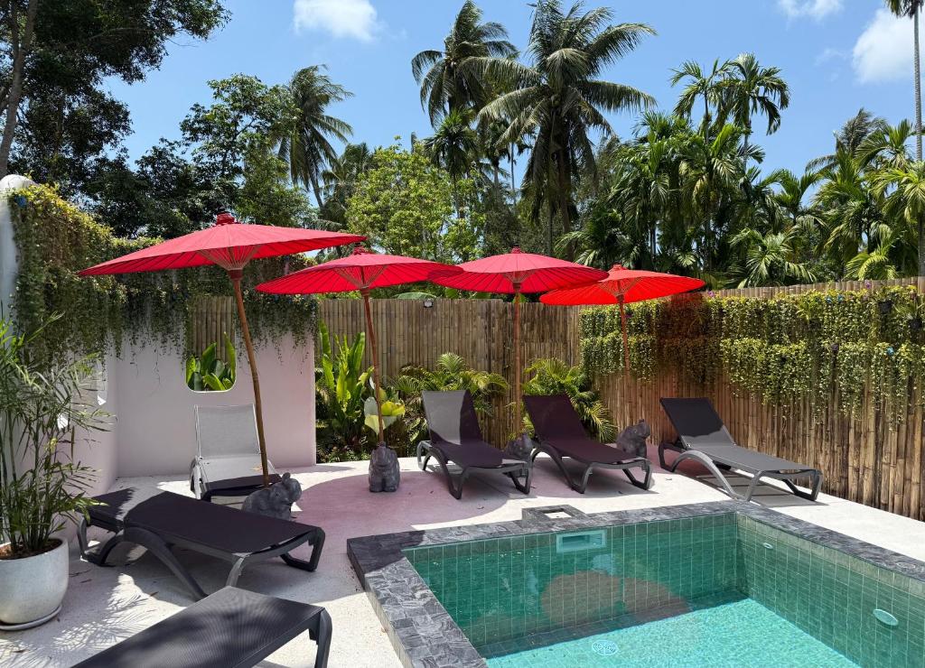 a patio with red umbrellas and a swimming pool at Aranya Bliss Villa 104 in Wok Tum