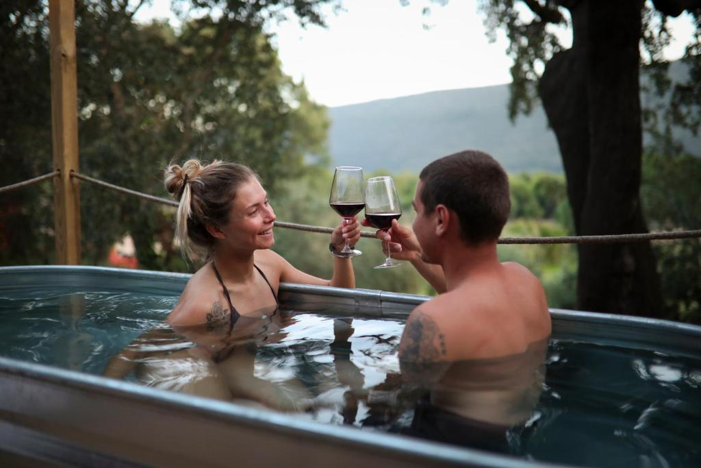 a man and woman drinking wine in a hot tub at Zaire Lodge in Mira