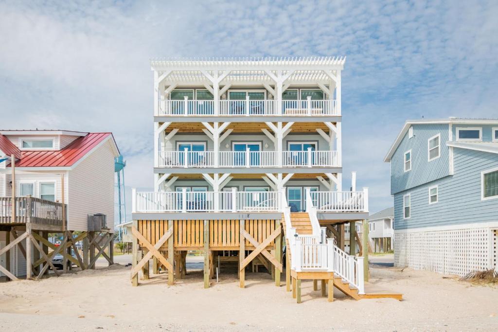 a large house with a deck on the beach at Saltwater Blessing by Oak Island Accommodations in Oak Island