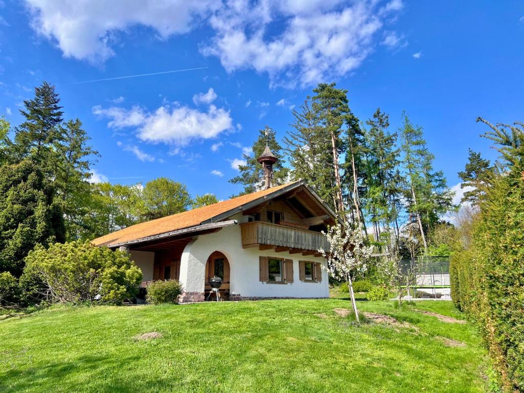 a house on a hill with a grass yard at Ferienhaus Eichenseer Gallzein - Alleinlage mit Garten, Wald & Bergblick in Gallzein