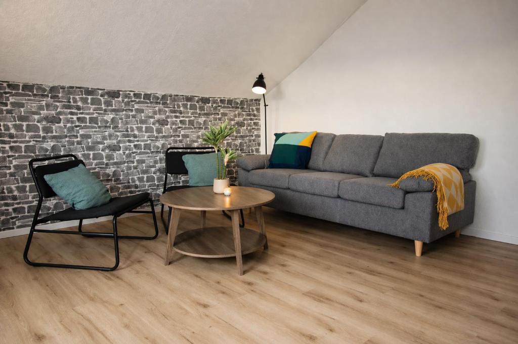a living room with a couch and two chairs and a table at Helle Ferienwohnung im Schwarzwald - 2 Schlafzimmer - WLAN - Holzapfel Apartments in Villingen-Schwenningen
