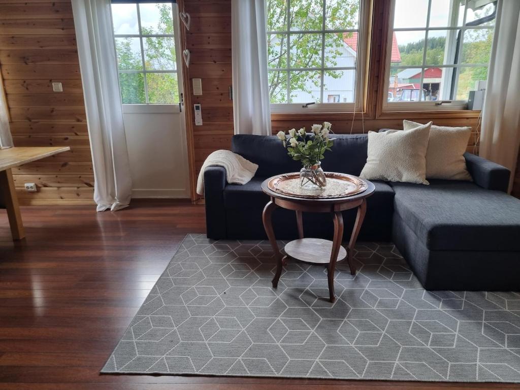 a living room with a blue couch and a table at Cozy cabin close to nature in Sorreisa