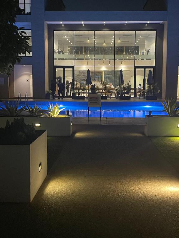 a night view of a restaurant with blue lights at Embassy Gardens Studio Accra in Accra