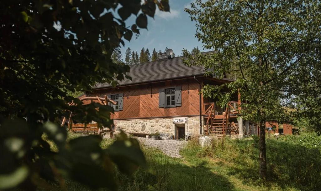 a large wooden house in the middle of a field at Kamp Soblówka in Sablówka