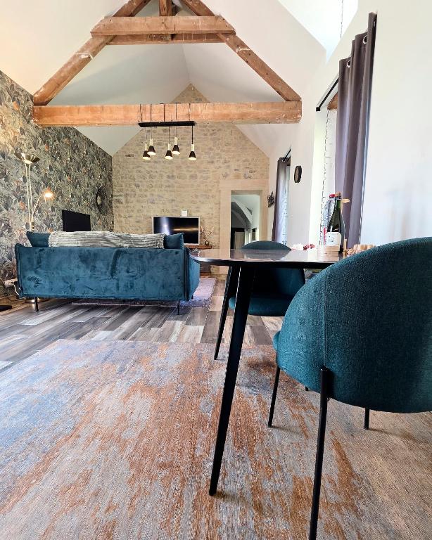 a living room with a couch and a table and chairs at Gite Les Petits Monts in Commes