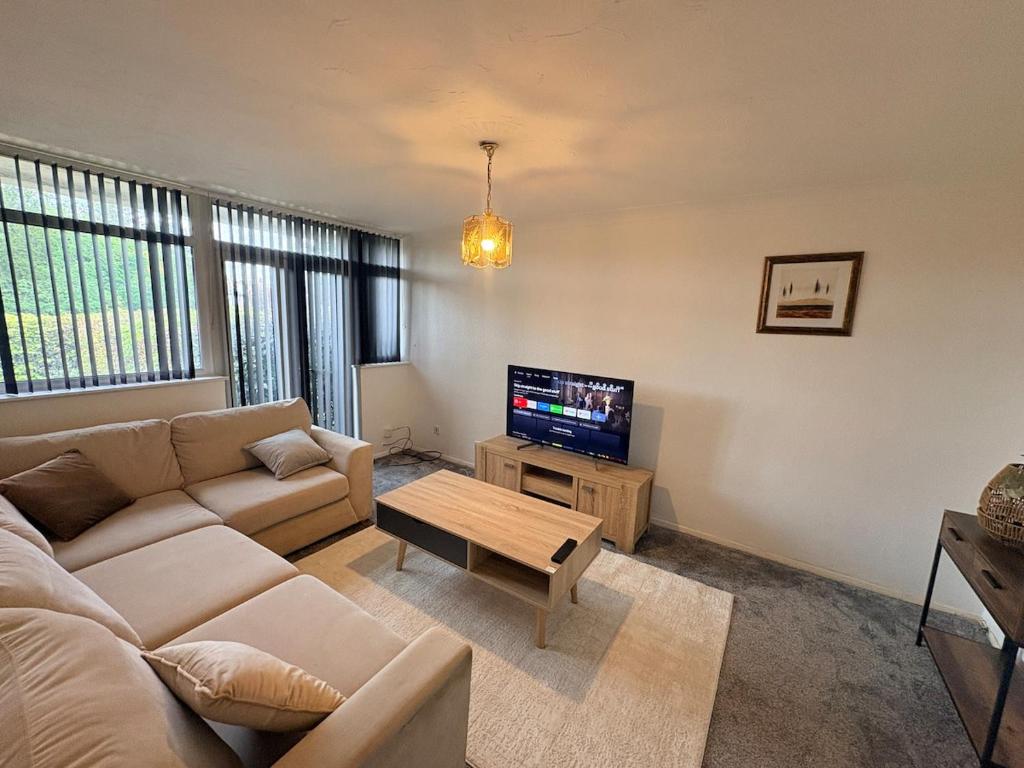 a living room with a couch and a tv at Sycamore haven in Spinney Hill