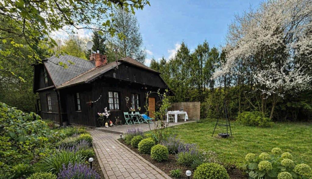 a small house with a garden in front of it at Chata Wróżki Mrozowej in Kazimierz Dolny