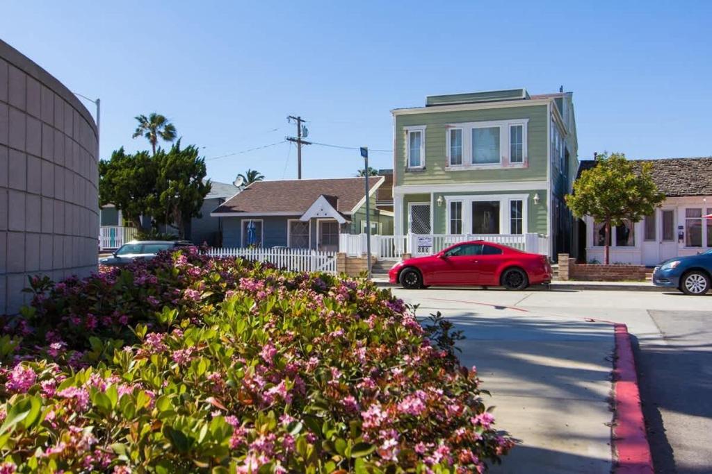 a red car parked in front of a house with flowers at 209 38th St. B Condo in Newport Beach