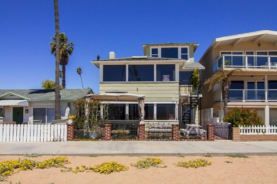 a house with a white fence and a palm tree at 1002 East Oceanfront in Newport Beach