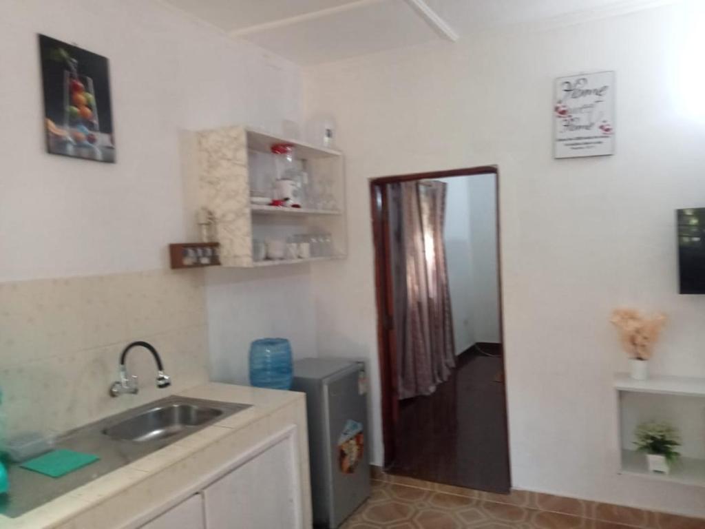 a small kitchen with a sink and a refrigerator at bluemoon in Watamu