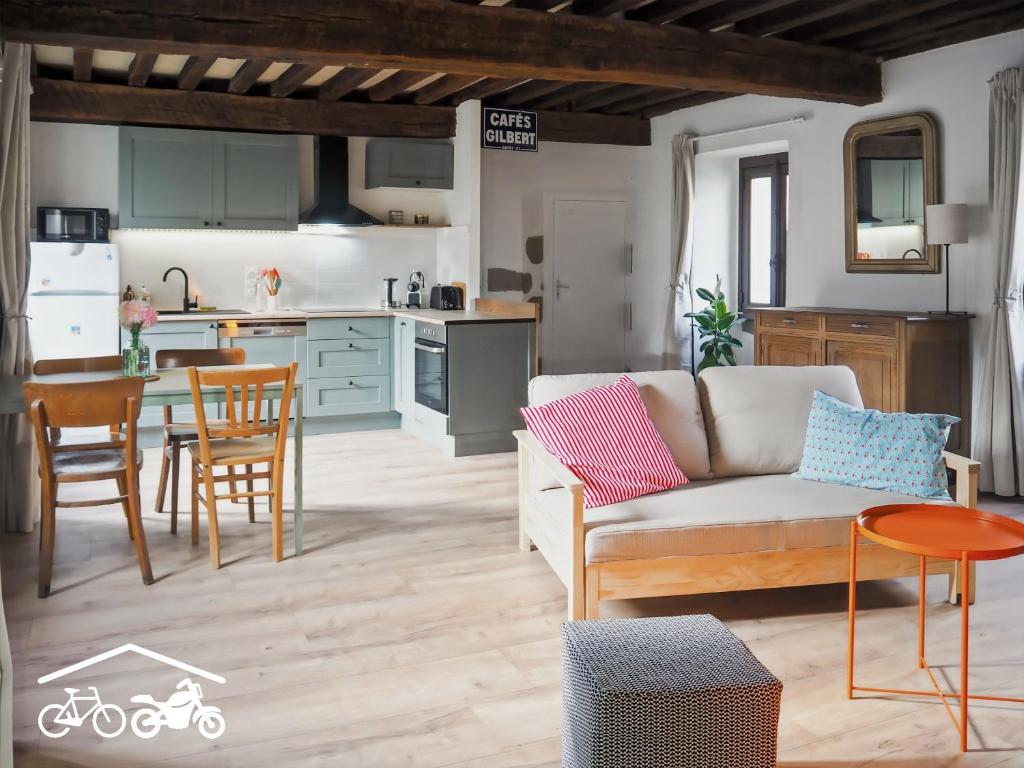a living room with a couch and a table at Chez Philomène in Aubusson
