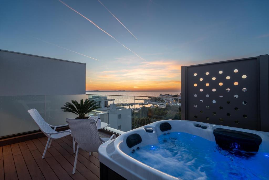 a hot tub on a balcony with a view of the ocean at Dedaj Resort - Penthouse Auri in Zadar