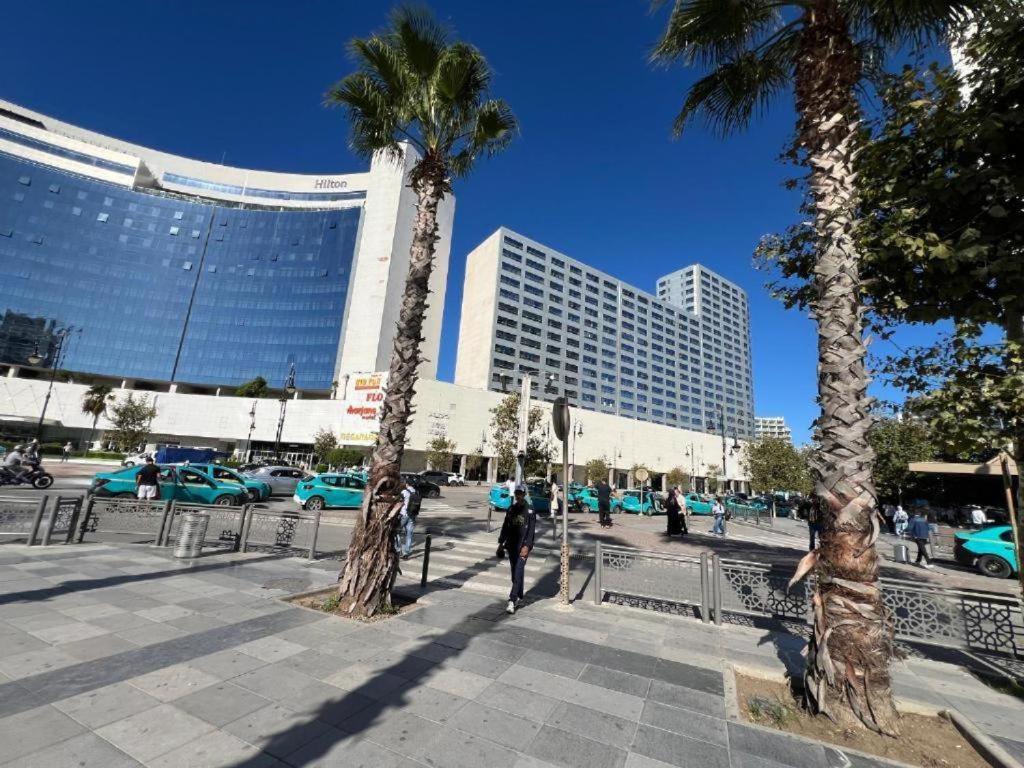 a group of palm trees in a city with buildings at Hilton Tanger View Tower 15D in Tangier