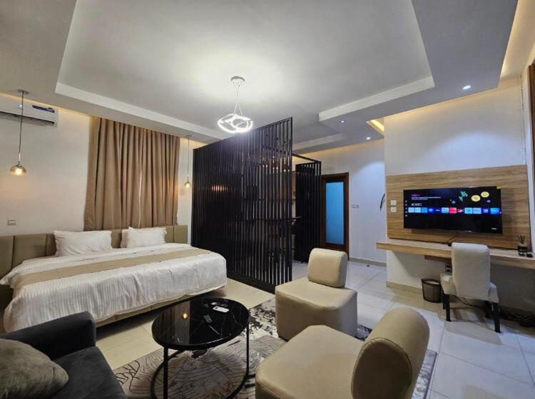a hotel room with a bed and a tv at Admiralty in Araromi