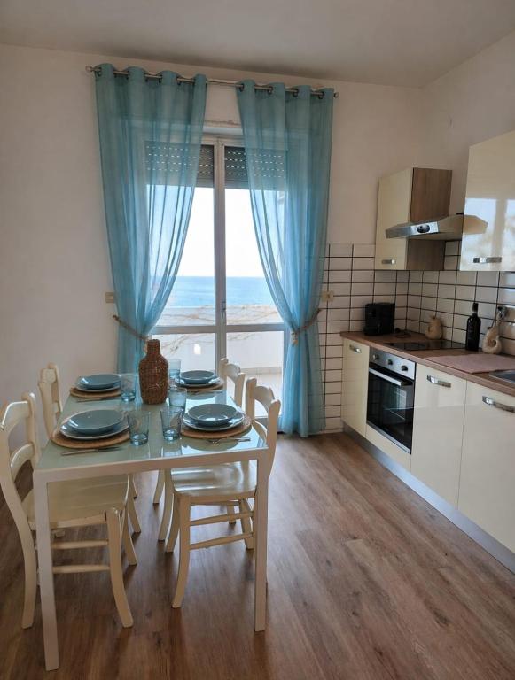 una cucina con tavolo e sedie e una finestra di Pubble beach apartment a Fossacesia