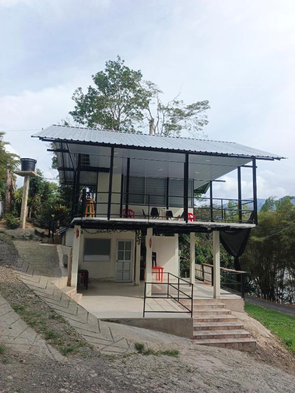 a house with a glass facade on a hill at Cabaña La Rivera in Macanal