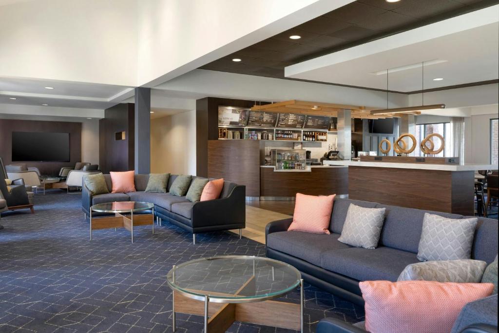 a lobby with couches and tables and a bar at Courtyard by Marriott Boston Norwood/Canton in Norwood