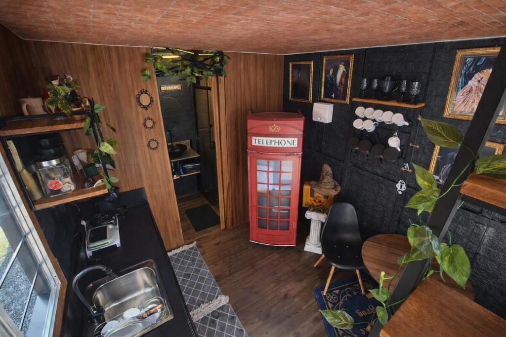 a room with a red telephone booth and a table at Lumos Experience in Guaratuba