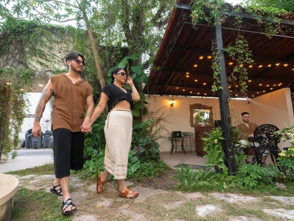 a man and a woman standing in front of a house at Esencia Valladolid Hotel in Valladolid