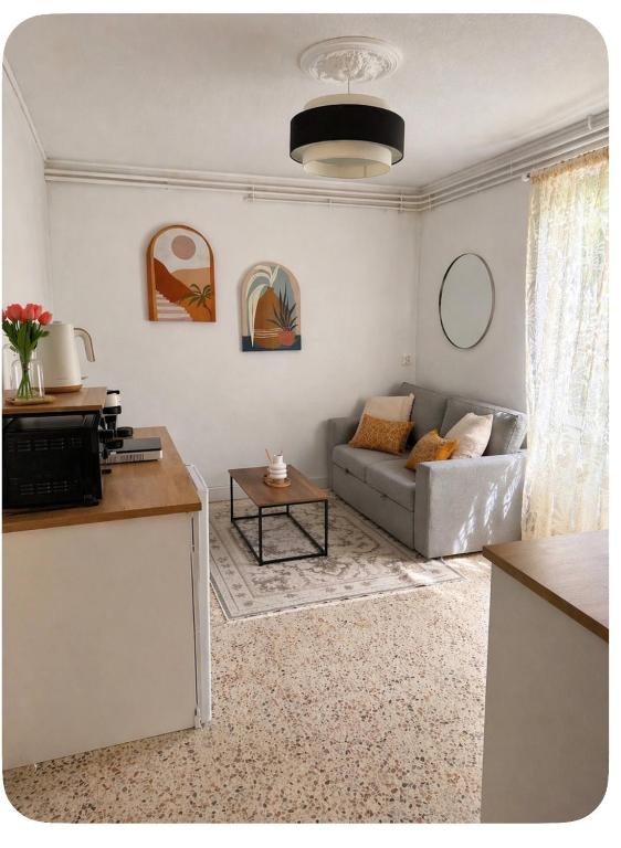 a living room with a couch and a table at Le Petit Rocher in Pierrelatte