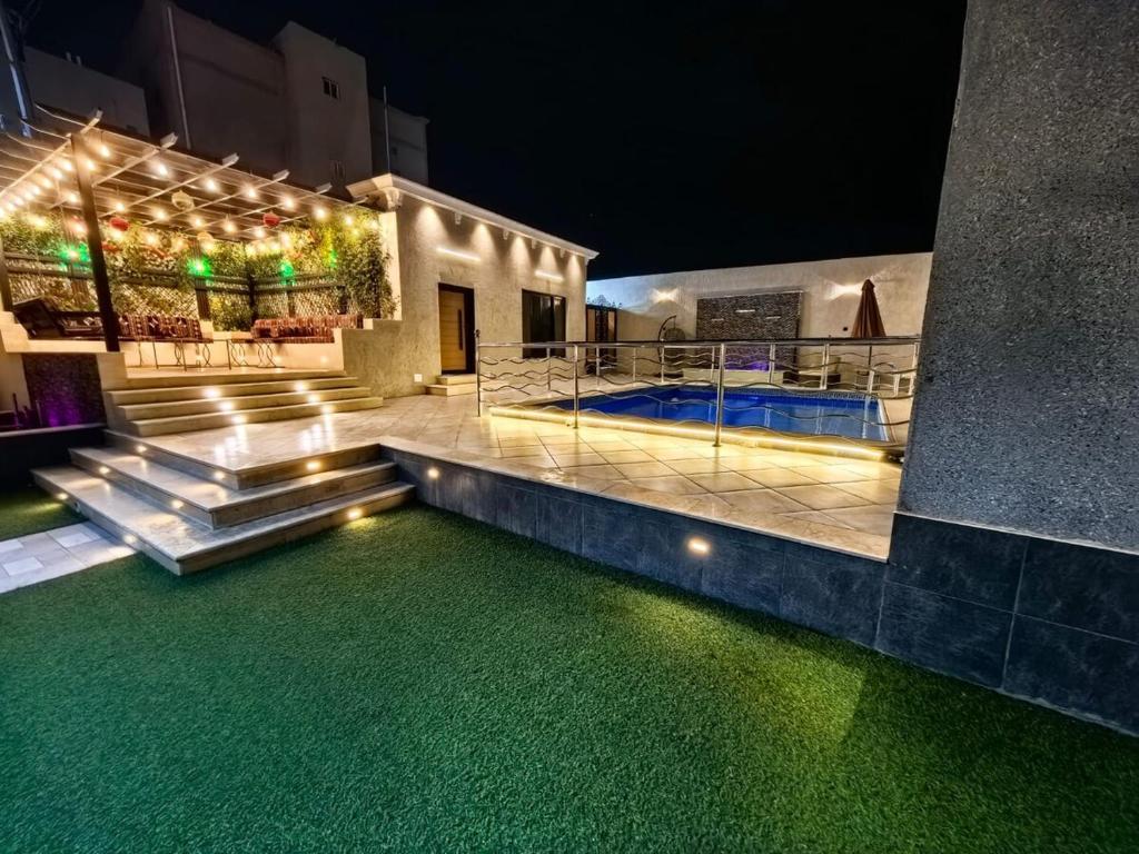 a house with a swimming pool at night at Welcome to Chalet Bonsiana! in Jeddah