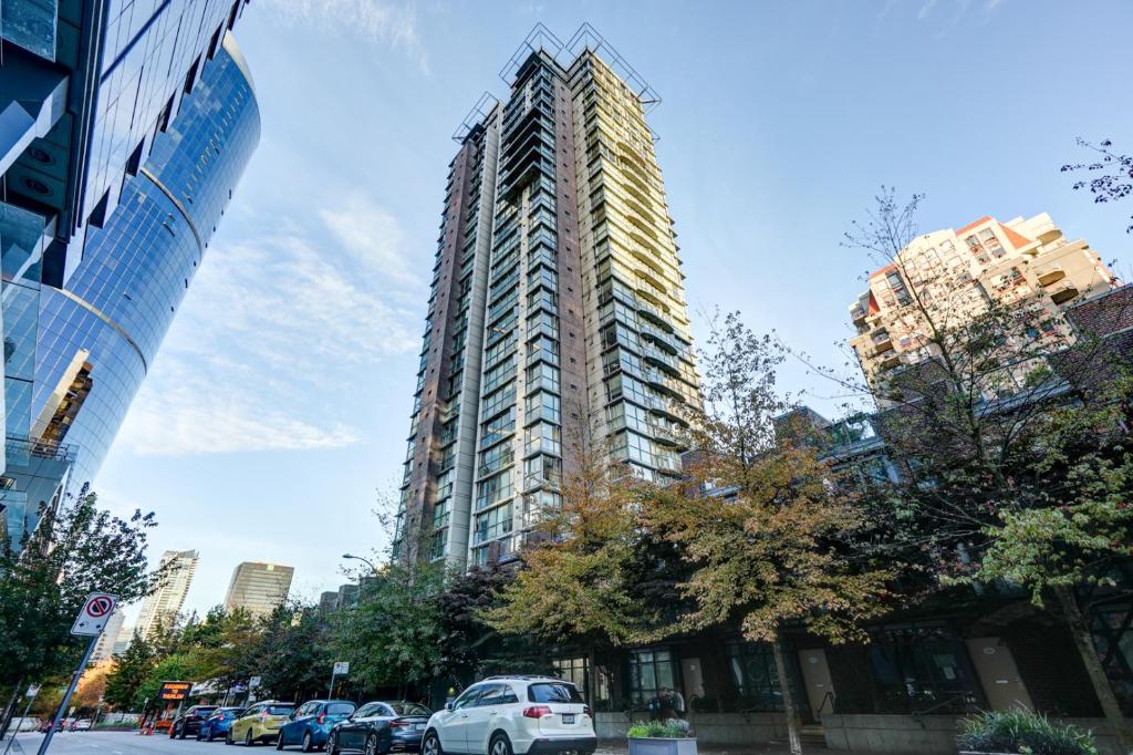 a tall building with cars parked in front of it at The Canadian in Vancouver