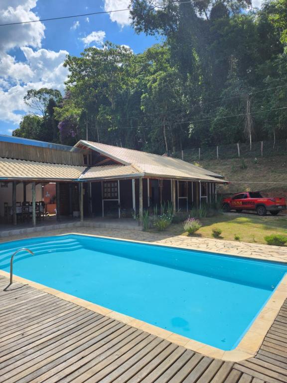 a swimming pool in front of a house at Chácara Pé da mata itajuba mg in Itajubá