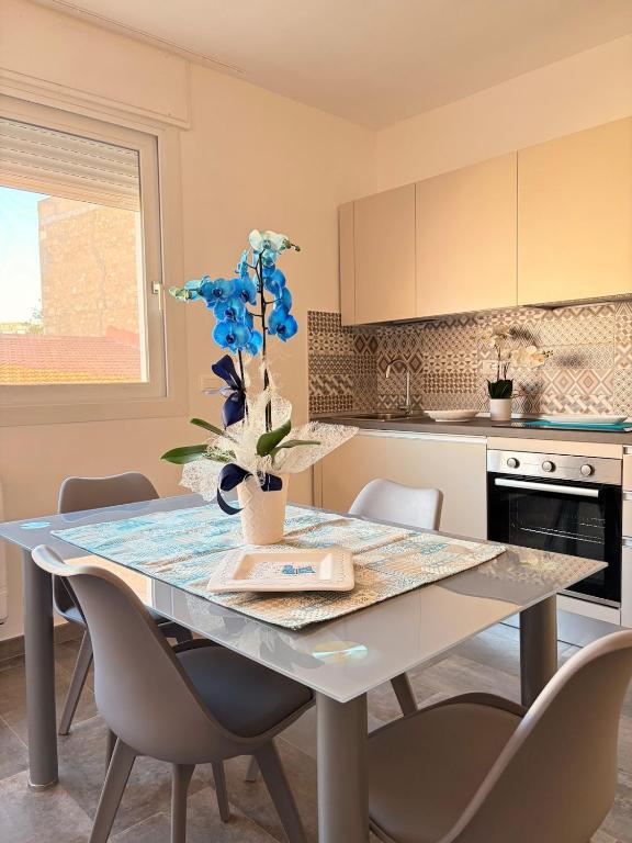 a kitchen with a table with blue flowers on it at Orchidea Apartments in Sorso