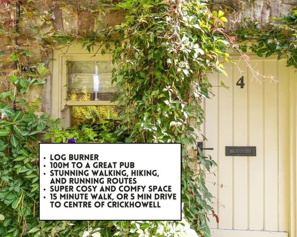a sign on the side of a building with a bush at Cosy Llangattock Hideaway in Crickhowell