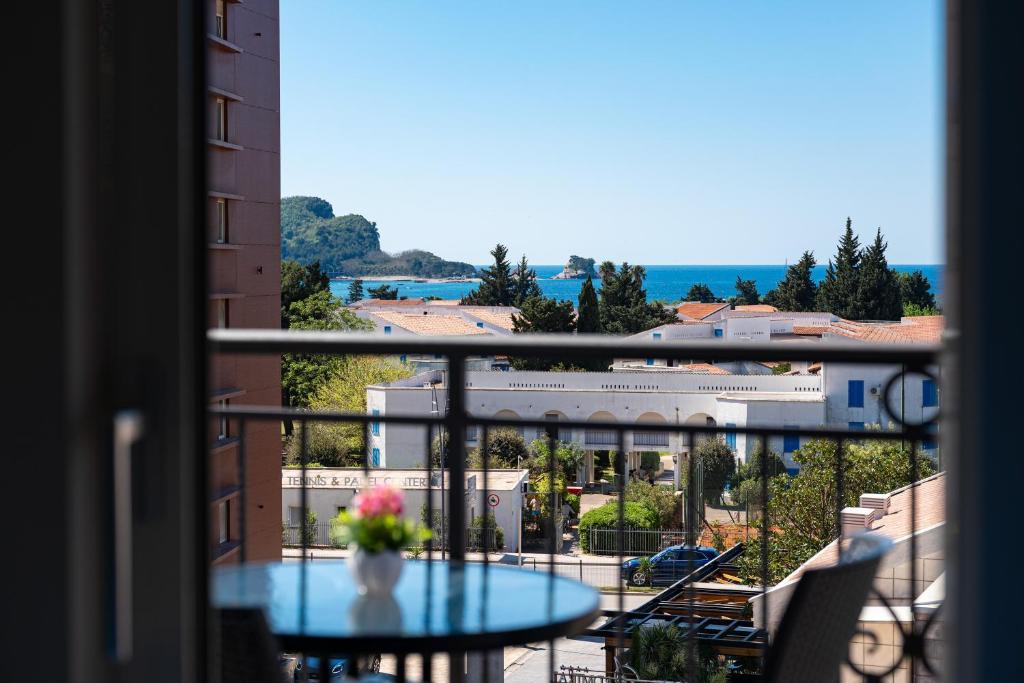 a table with a vase of flowers on a balcony at Villa Ines in Budva