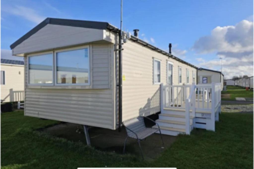 a tiny house sitting on the grass in a yard at Lyons Robinhood - 3 bedrooms in Rhyl
