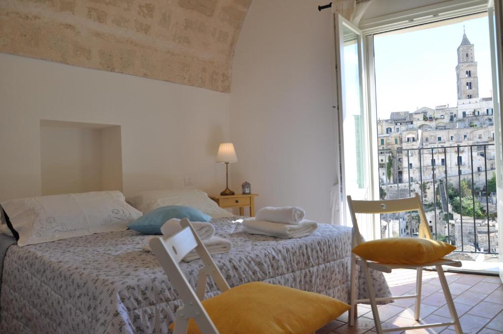 Un dormitorio con una cama y una ventana grande. en Roseus La Casa Vacanze nei Sassi, en Matera