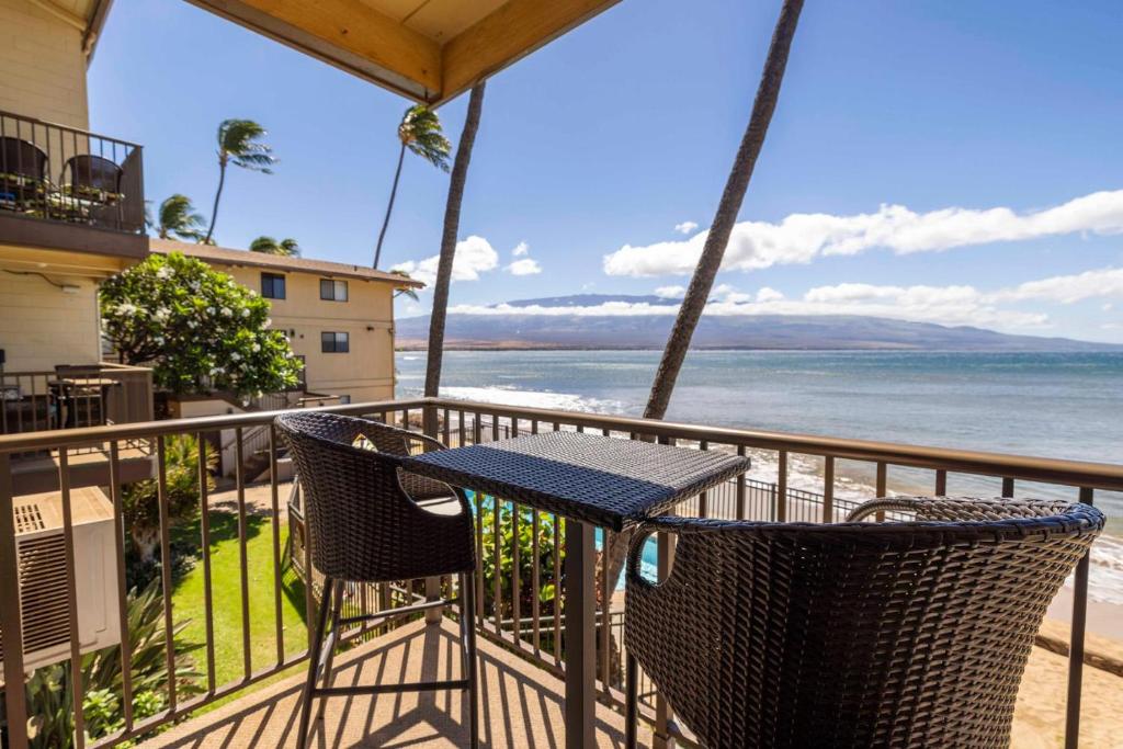 a table and chairs on a balcony overlooking the ocean at Hono Kai Resort B7 in Wailuku