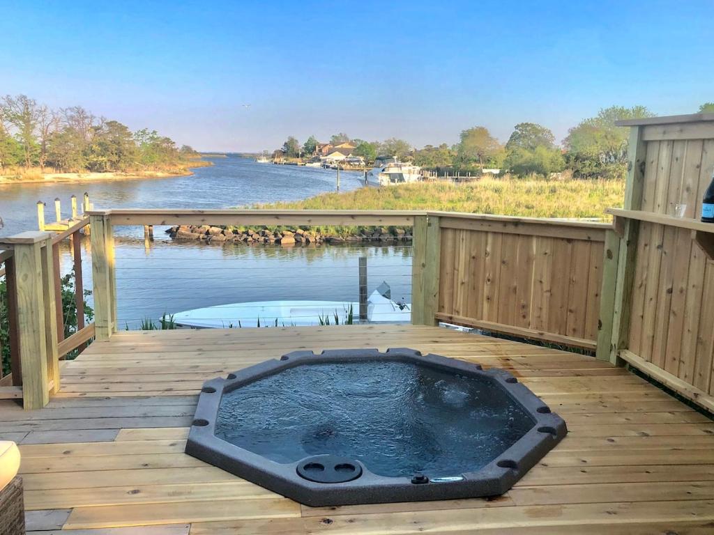 a hot tub on a deck next to a body of water at Waterfront Round House View in Oakdale