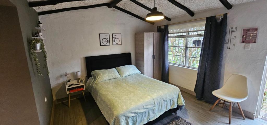 a bedroom with a bed and a chair and a window at Aparta estudio campestre in Chía