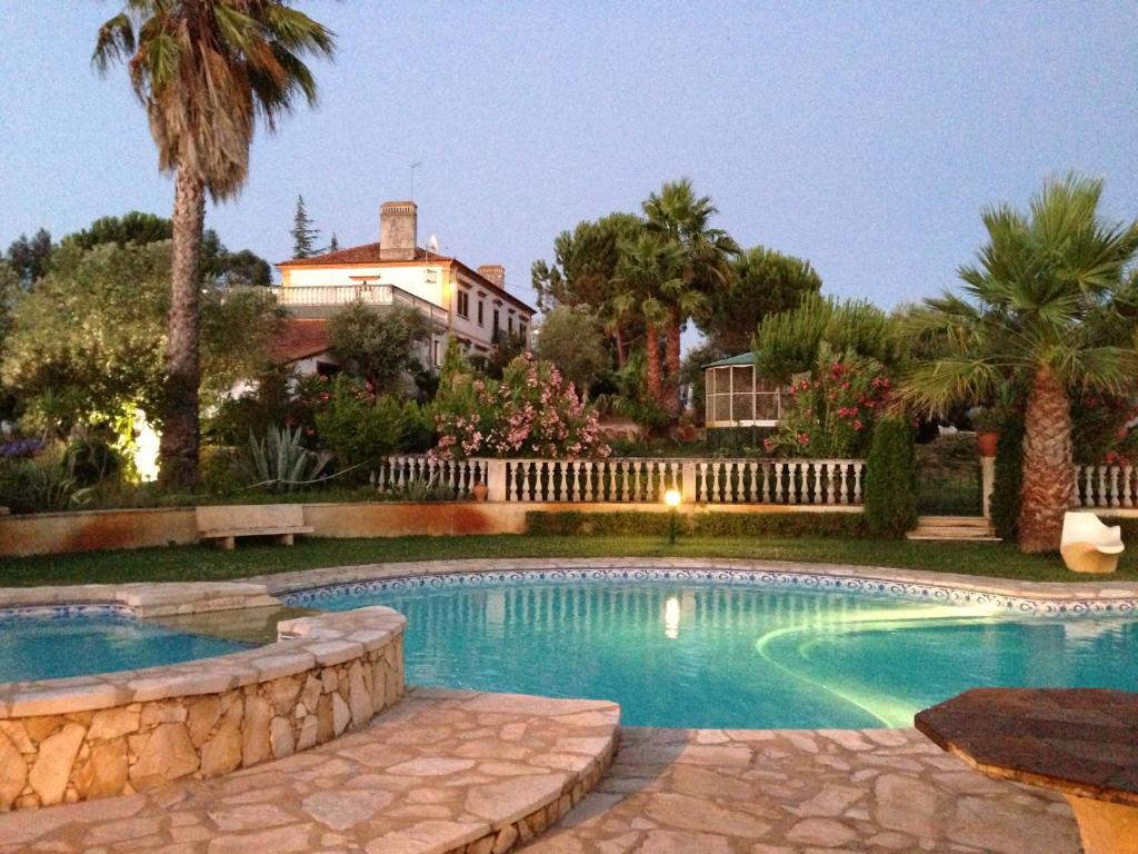 a swimming pool in front of a house at Quinta do Pinhal in Constância