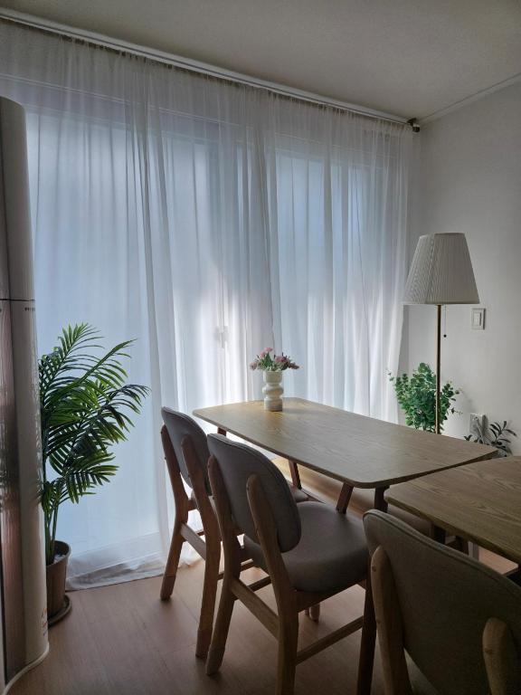 a dining room table with chairs and a large window at SNU Station 13min, Line 2, Hongdae,Gangnam 30min, 6pax in Seoul