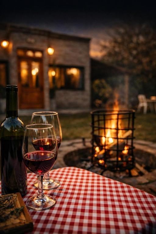 a glass of wine sitting on a table with a bottle of wine at MARGAHOME in Maipú