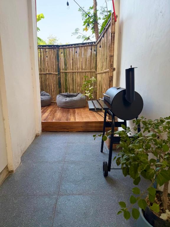 a room with a patio with a grill and a fence at Pads Guesthouse in San Vicente