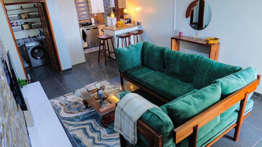 a living room with a green couch and a table at The apartment Bwebajja 3 in Namulanda