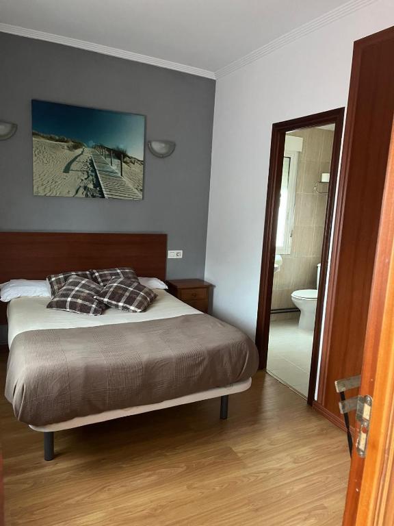 a bedroom with a bed and a bathroom at Pensión Restaurante Verdemar in Vigo