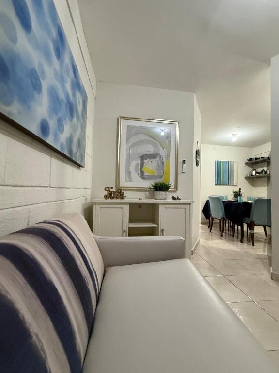 a white bedroom with a bed and a dining room at Confortable estancia de 1 a 4 personas in Guamúchil