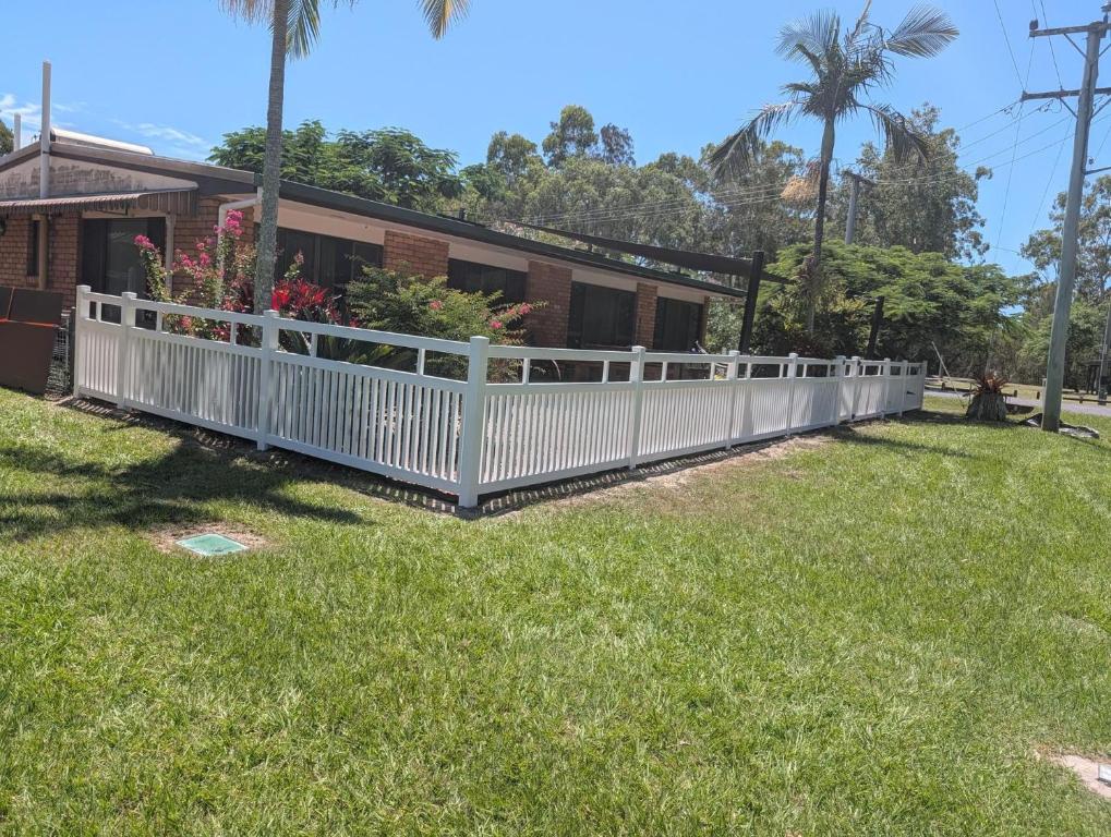a white fence in front of a house at Yolanda - Burrum Heads- Beachfront - 3BR- Aircon in Burrum Heads